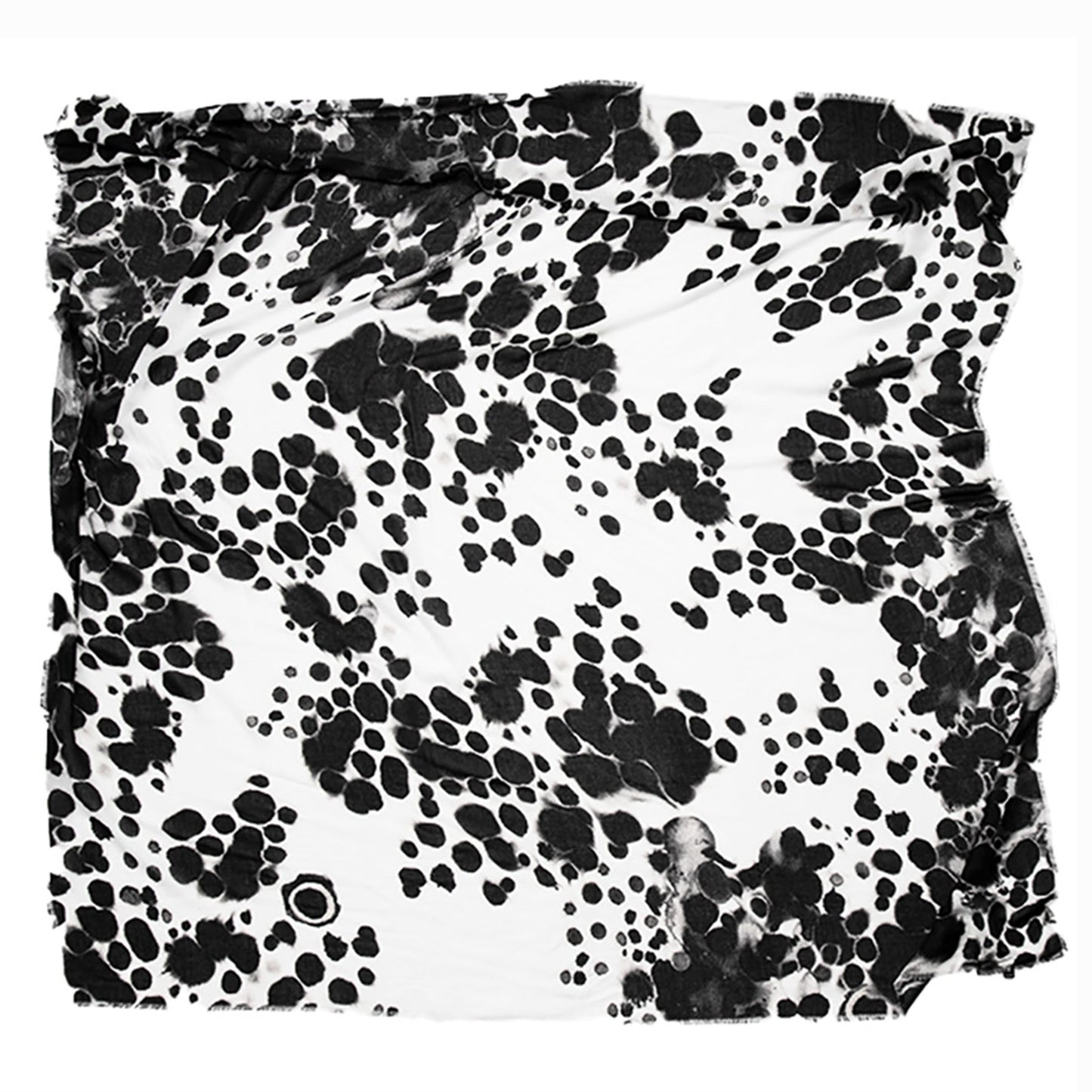 Flat lay of the Elios scarf by Hunter Christian, showing its black-and-white signature pattern inspired by sumi ink and animal markings, crafted from vegan modal with hand-frayed edges.